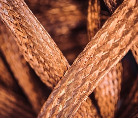 Close up of braided copper cable or cordage with a tight, basket-weave pattern