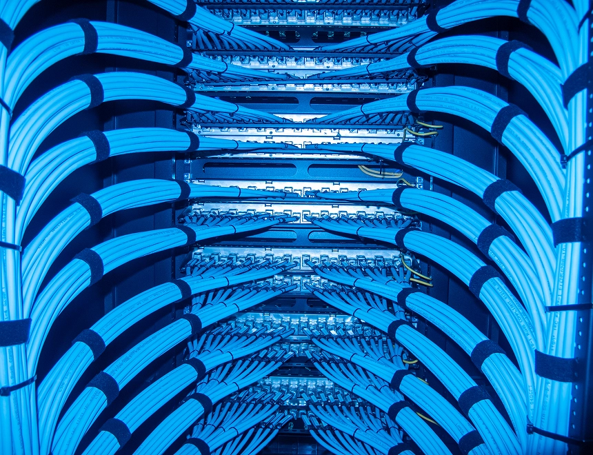 Extreme close-up of a thick, flat copper bar with a single, precisely drilled bolt hole, lit with a warm industrial glow