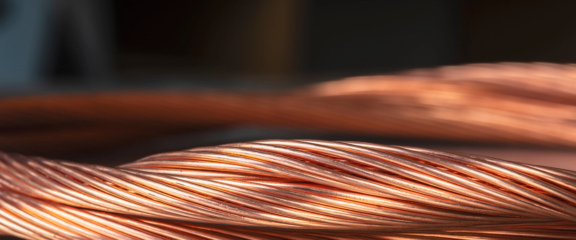 Close up of a thick, flexible cable made of multiple strands of twisted copper wire, showing the individual wire pattern.